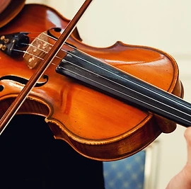 Close-up of a musician performing a musical composition using a violin and a bow. Violin m